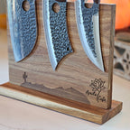 Three knives on a wooden stand with 'April's Cafe' engraved.