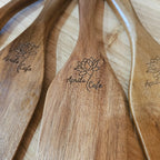 Wooden spoons with 'April Cafe' engraved logo on a wooden surface